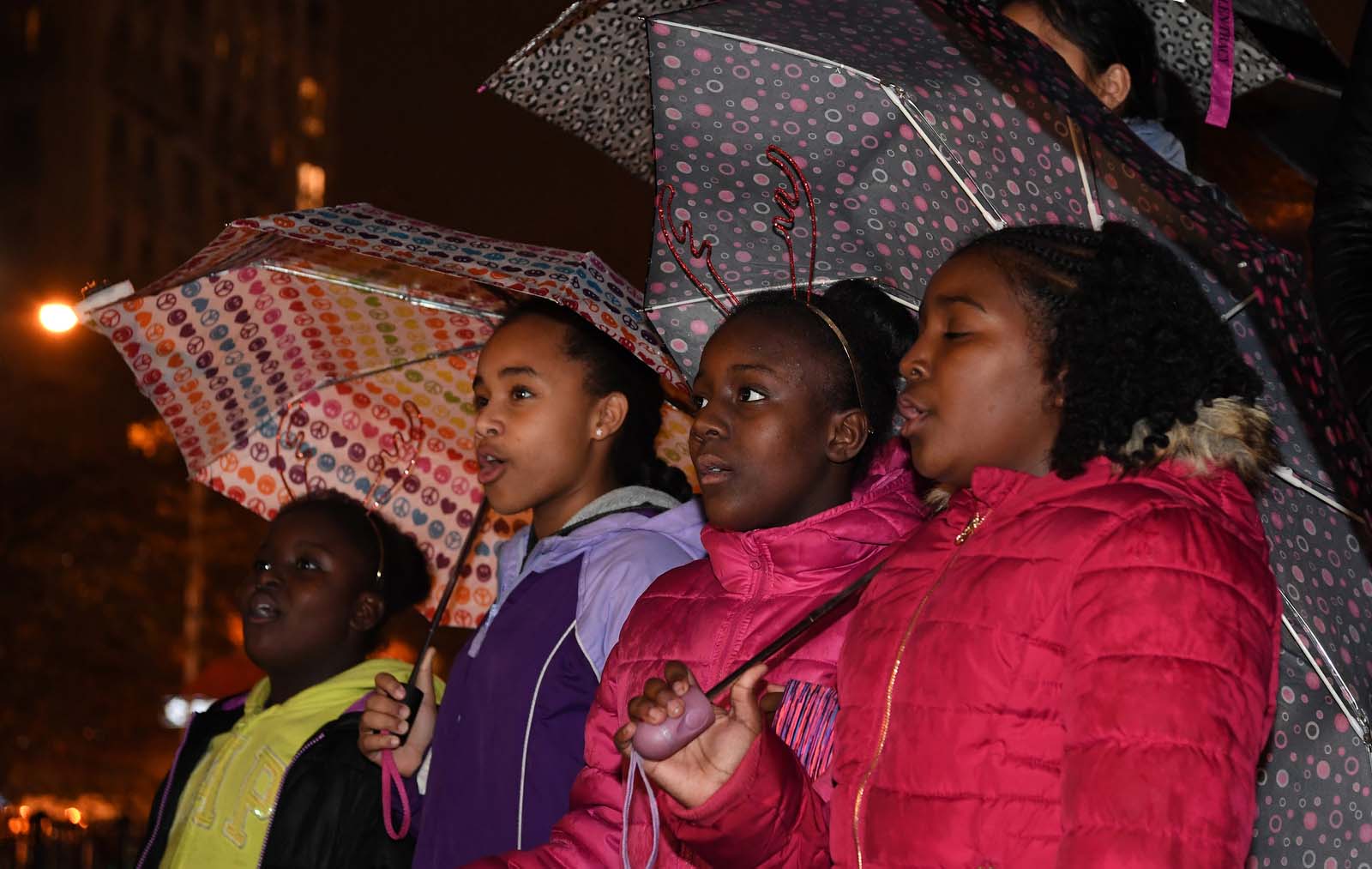 four children singing with umbrellas